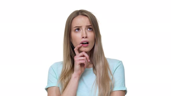 Portrait of Thoughtful Woman in Casual Tshirt Reflecting or Doubting Holding Finger on Lips Isolated