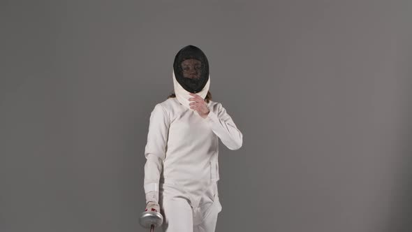 Portrait of Charming Female Fencing Athlete in White Uniform on Gray Studio Background