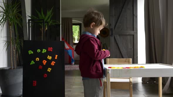 little boy learns and play with letters at home