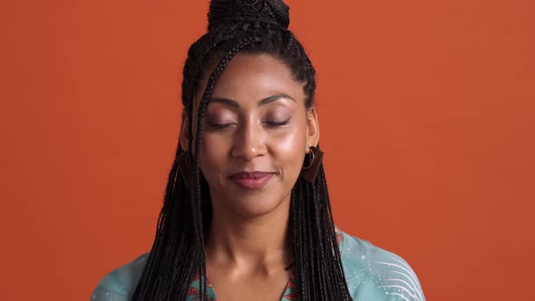 A close-up view of a calm african american woman opening her eyes and looking to the camera