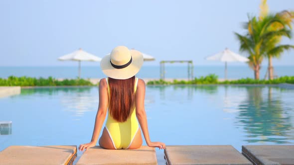 Young asian woman enjoy around outdoor swimming pool for leisure