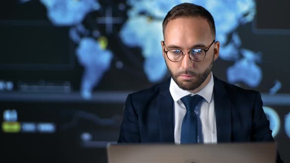 Male Boss Working Internet Laptop at Illuminated Hi Tech Screen with Graph Scheme and Global Map