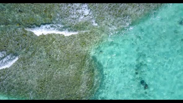 Aerial top down abstract of luxury tourist beach adventure by aqua blue ocean with white sandy backg