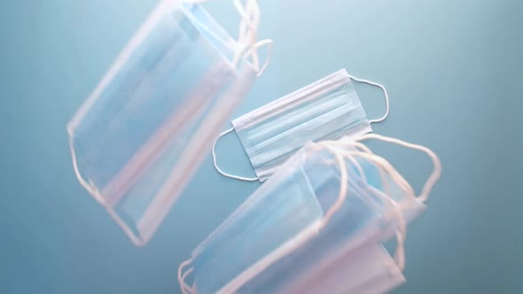 Top View of Blue Surgical Masks Falling on Blue Background