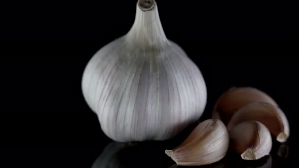 Closeup of an Organic Garlic Head Lying on a Table Isolated Against a Dark Background
