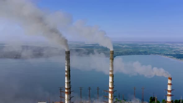 Aerial view of coal power plant high pipes with black smokestack polluting atmosphere
