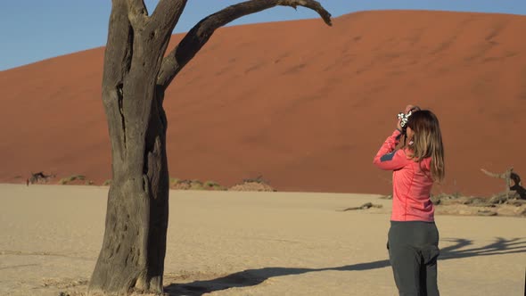 Woman taking photos of tree in Deadvlei, Namibia