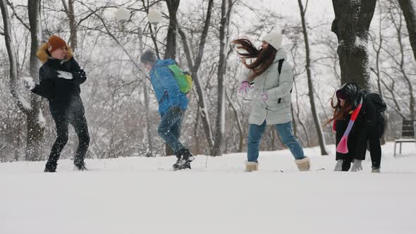 Children Have Fun Throwing Snow at Each Other in City Park