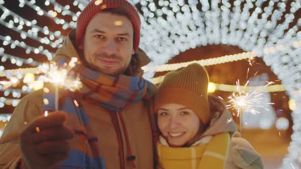 Portrait of Romantic Couple with Sparklers in Tunnel of Lights