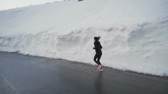 Lonely Jogger with Bright Pink Running Shoes Sprinting in Snow Corridor in Bulgarian Mountains