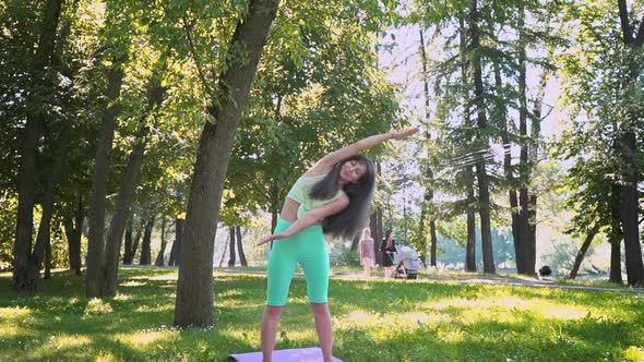 Caucasian Woman Sportswear Trains Asana Yoga Green Lush Grass Sunny Weather Doing Lotus for