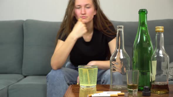 a woman suffers from a hangover, she drinks painkillers in a glass of water