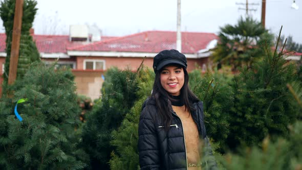 A beautiful woman in a happy holiday spirit smiling while shopping for festive douglas fir Christmas