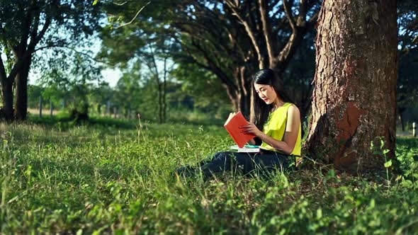 woman sitting on grass and reading a book in the garden