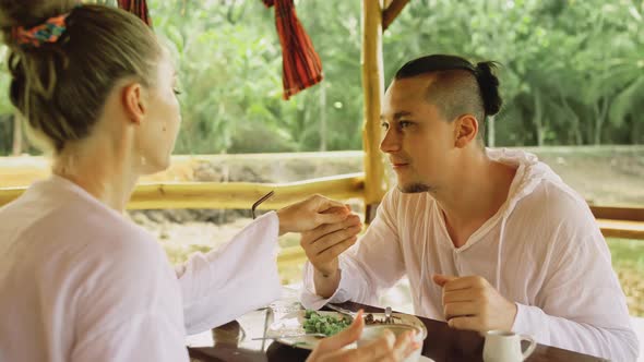 Man and Woman Eat and Drink Tasty Beverages Spending Time in Traditional Local Floating Cafe on