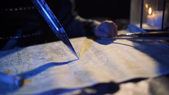 Commander working on map with sword in hand. alt