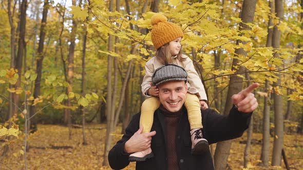 Kind Father Shows Park in the Autumn To Daughter