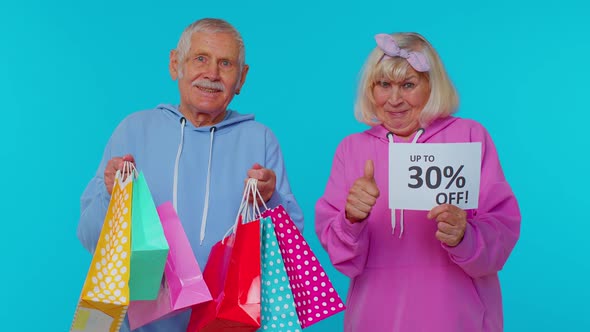 Senior Grandparents Showing Shopping Bags and Up To 30 Percent Off Banner Text Black Friday Holiday