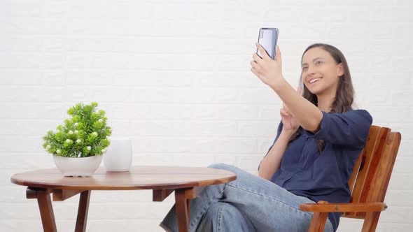 Indian girl taking selfies at a restaurant