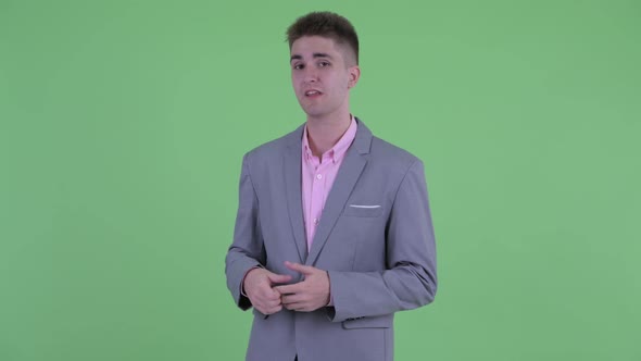 Happy Young Businessman Talking To Camera