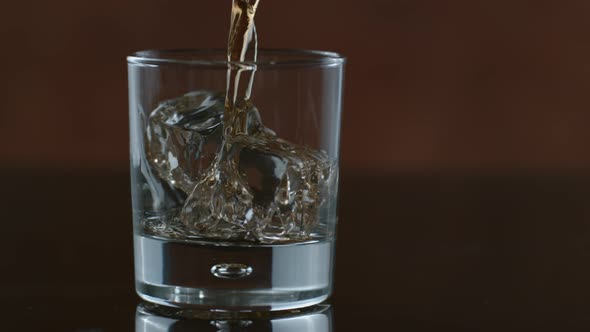 Whisky is poured over ice in slow motion; shot on Phantom Flex 4K at 1000 fps alt