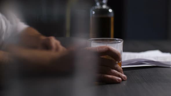 Man Releiveing Stress with Glass of Whiskey