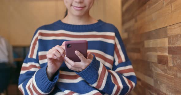 Woman work on cellphone inside coffee shop