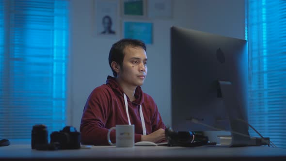 Asian young man working from home at night