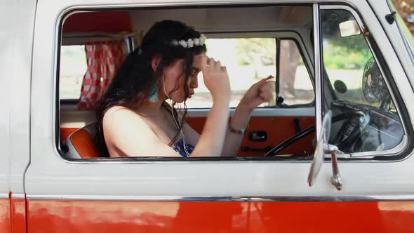 Woman enjoying music while sitting in camper van 4k