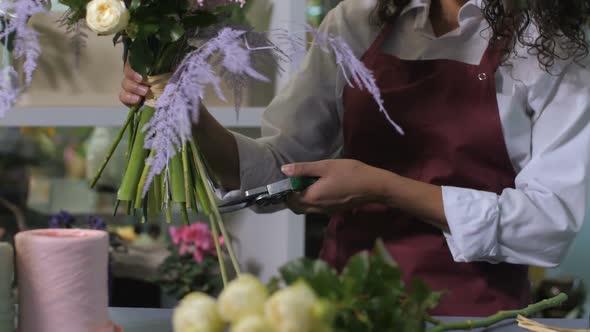 Florist Hands Cutting Flower Stems in Workshop