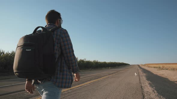 A man walking with his dog on the road