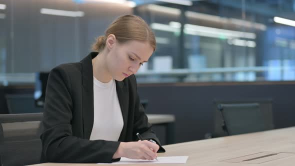 Businesswoman Trying to Write on Paper in Office