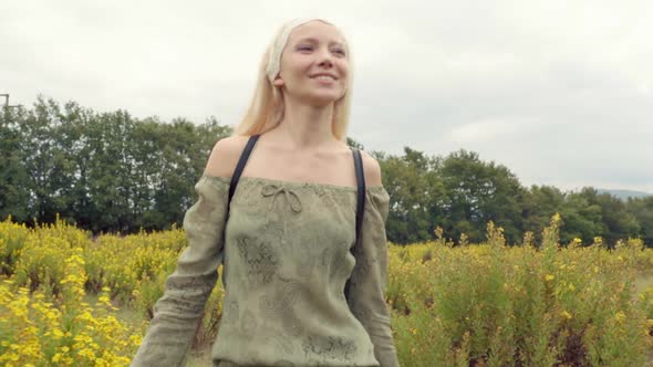 Front View of Beautiful Blond Young Girl Walks Outdoor in Nature Toward Camera Smiles Laughs and Fun