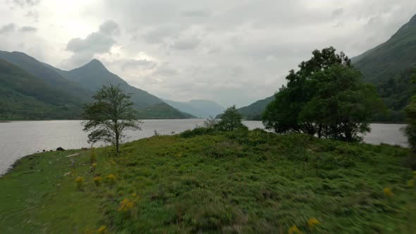 Low drone shot over small island in Scottish Loch leven