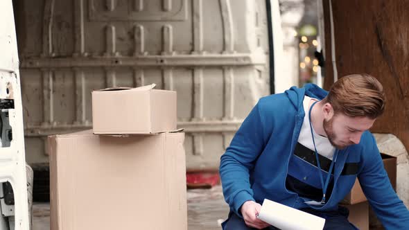 Delivery Driver Checking His List of Parcels