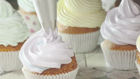 Squeezing Pink Cream onto the Cupcake.