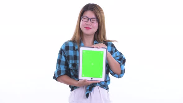 Happy Young Asian Hipster Woman Thinking While Showing Digital Tablet