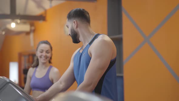 Side View of Young Man Giving High Five To Smiling Woman After Training. Positive Middle Eastern Guy