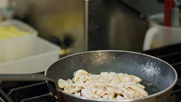 Slow motion of chicken meat fried in a pan with sauce