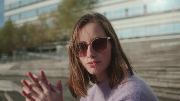 Young Woman In Sunglasses With Hands Clasped