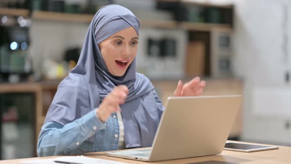 Excited Arab Woman Celebrating Success on Laptop