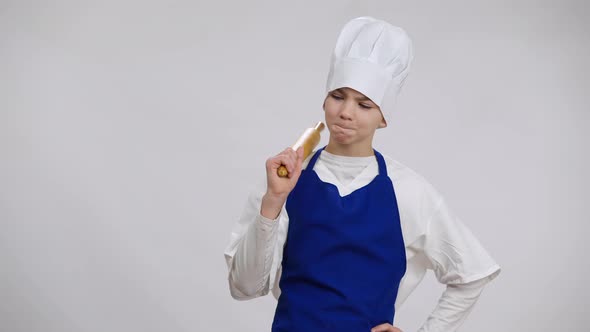 Portrait of Confident Little Chef Cook Hanging Rolling Pin on Shoulder Smiling Looking at Camera