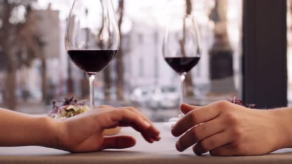 Close Up Shot of Romantic Couple Holding Hands in Cafe Dating with Wine Glasses Slow Motion