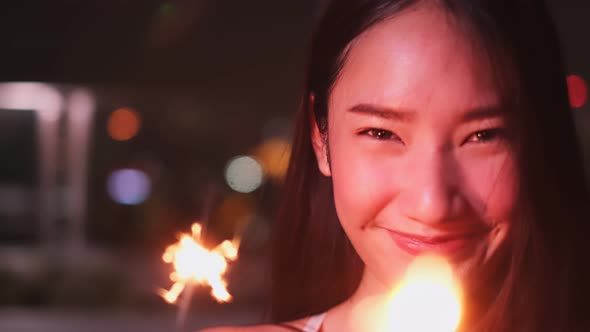 Young asian woman with sparklers is dancing and celebrating a new year. Fireworks,