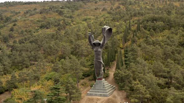 Aerial Drone Pan Shot Left To Right of Statue in Vake Park in Tbilisi