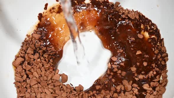 Pouring hot water in cup with freeze-dried soluble coffee granules, high angle view