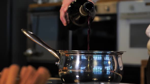 Closeup Man Pouring Red Wine Into a Saucepan