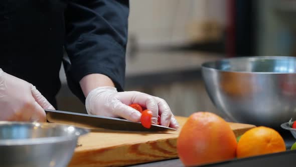 Chef Cutting Cherry Tomatoes on  Desk