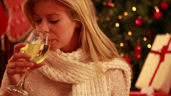 Pretty blonde sipping wine at christmas