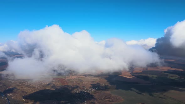 Aerial View From Airplane Window at High Altitude of Earth Covered with Puffy Cumulus Clouds Forming